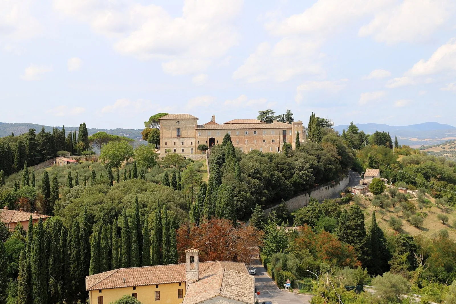 Le colline verdi di Perugia con cipressi e olivi e il convento di San Francesco del Monte a Monteripido, visti da Porta Sant'Angelo